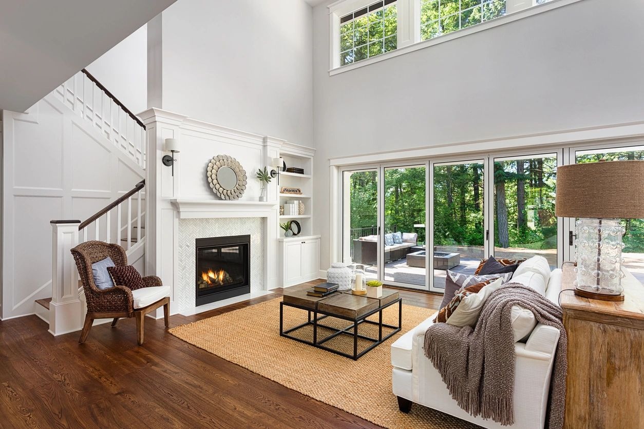 A living room with a fireplace and large windows.