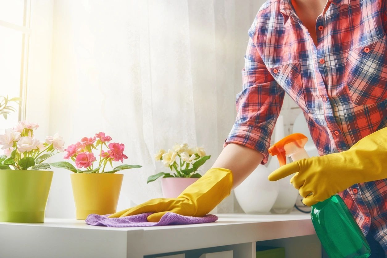 A person in yellow gloves cleaning the counter.